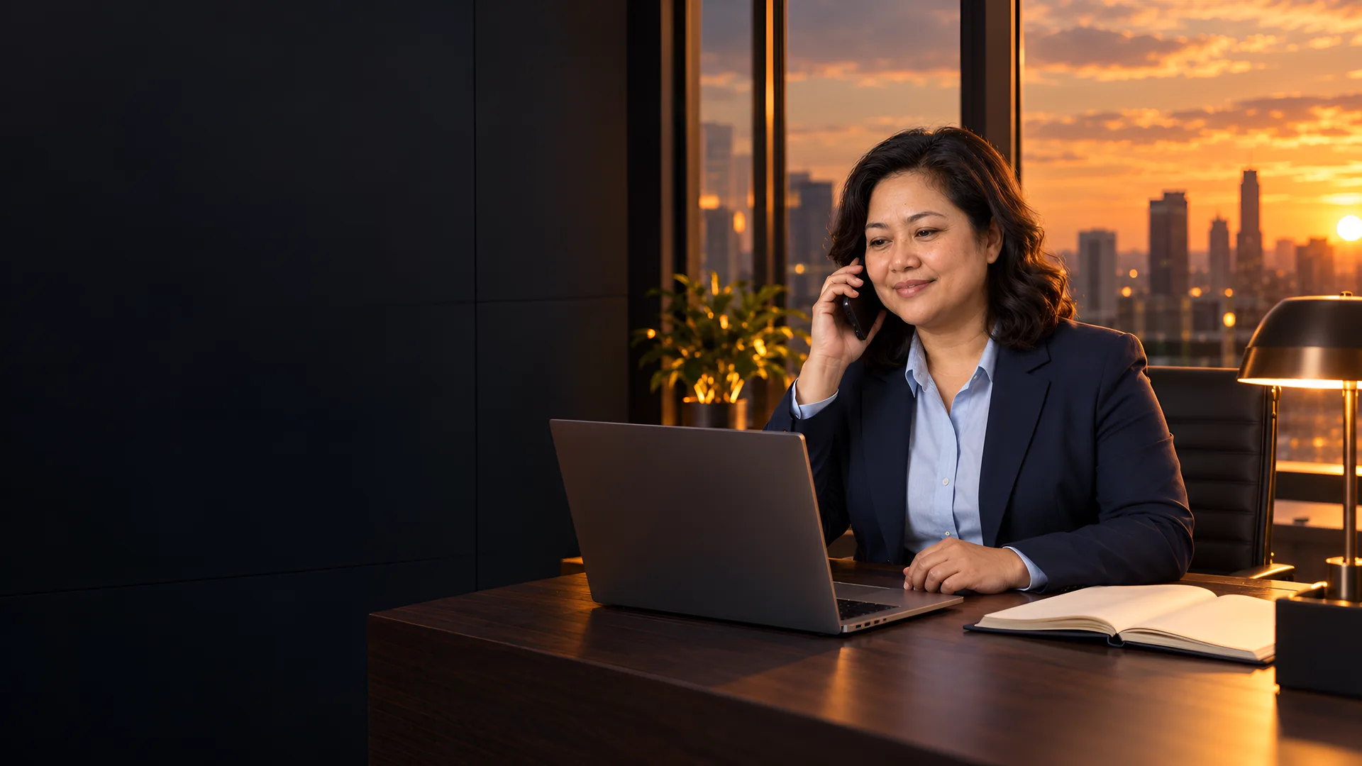 1SSC senior risk consultant speaking with a client by phone in an office at dusk.